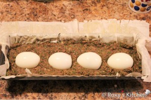 Lamb Haggis (Drob de Miel) - Add half of the mixture, arrange the hard-boiled eggs in the pan 