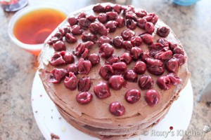 Topsy Turvy Chocolate Cake  - Add the thirdlayer, moist with syrup, spread chocolate ganache and add cherries.
