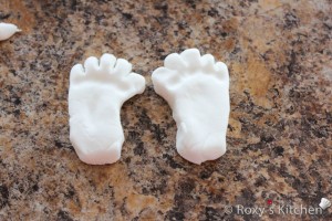 Take two small pieces of fondant and shape the baby feet. 