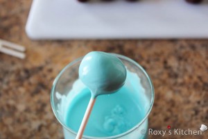 Gently tap the lollipop on the edge of the glass to remove excess melt.