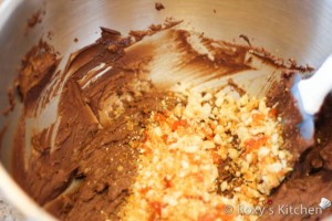 Mix in the chopped hazelnuts in 2/3 of the mixture. You will use the remaining to crumb coat the cake.  