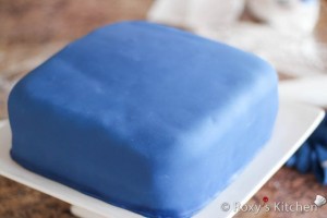 Smooth the fondant with the palm of your hands or a fondant smother and trim the edges at the bottom.