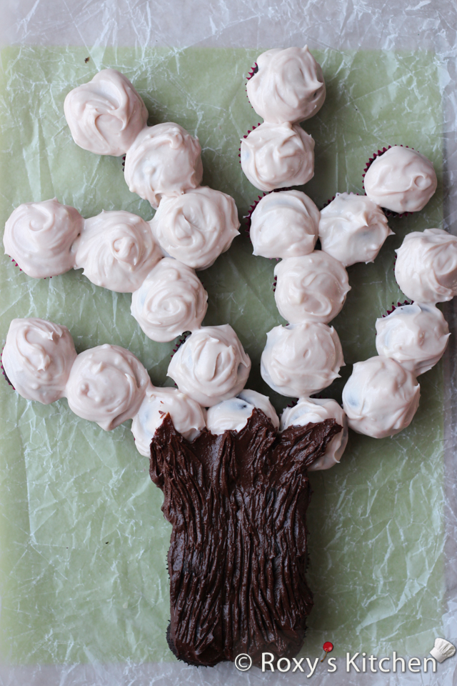 Spring Blossom Tree Made Out of Cupcakes - Cover the bottom six cupcakes generously with chocolate frosting to make the tree trunk and the remaining cupcakes with the light pink frosting. Drag a fork along the trunk to create bark on the tree.
