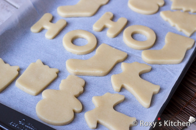 Christmas Sugar Cookies Covered with Modeling Chocolate - On a lightly floured surface roll the dough until it’s about ¼ inches thick. Using the cookie cutters, cut out the dough and place the cookies in a baking pan lined with parchment paper.
