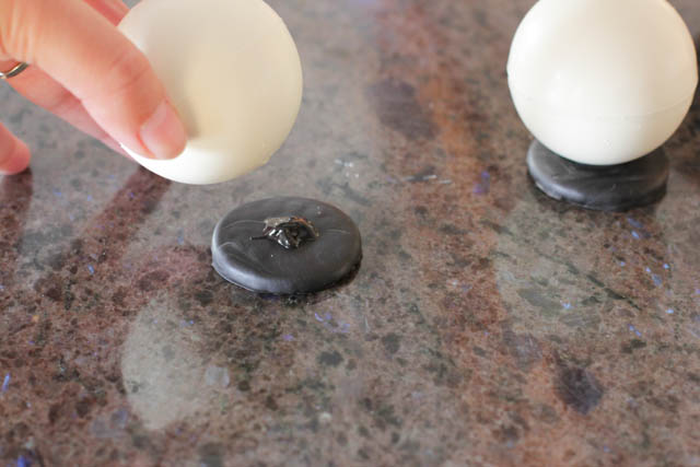 Assembling the chocolate snowmen - Place a bit of melted chocolate on the Oreo cookie base and attach the chocolate ball to each cookie (with the tiny hole facing down). Refrigerate them for 15-20 minutes. 