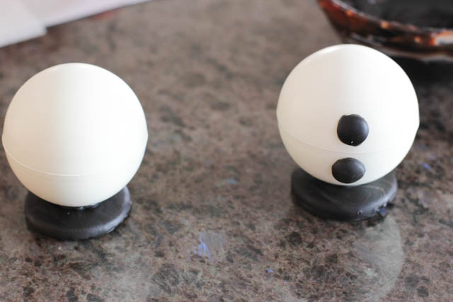 Assembling the chocolate snowmen -Attach the buttons using a drop of melted chocolate. 
