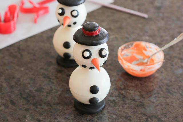 Assembling the chocolate snowmen -Lastly, insert half a toothpick in the hat hole and attach it to the snowman using a bit of melted chocolate. 