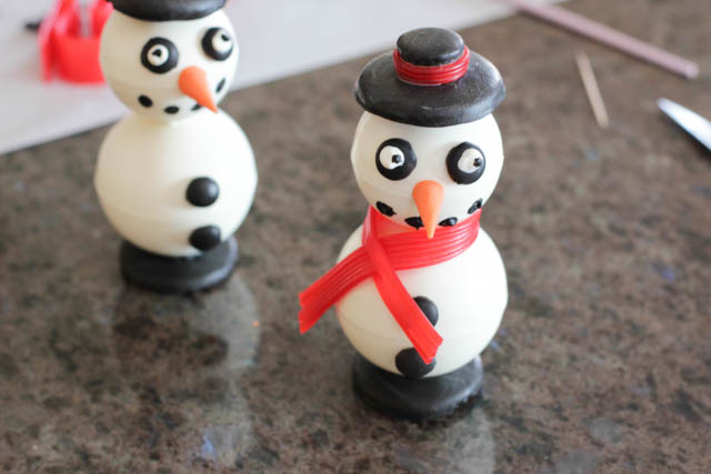 Assembling the chocolate snowmen - Then, wrap the scarf around the snowman and pass the other end through the slit you just made. 