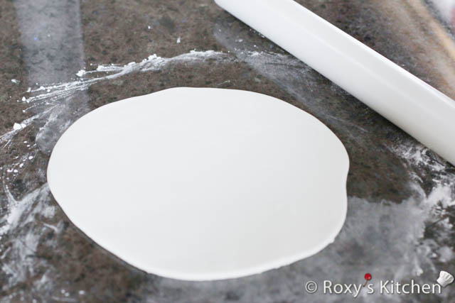 Dust your working surface with cornstarch and roll the gum paste around 4 mm (1/6 inches) thick and 25 cm (10 inches) in diameter.