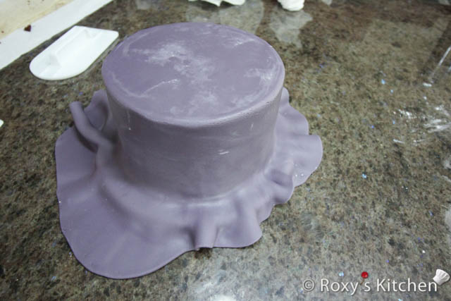 Then, cover the cake with purple fondant. 