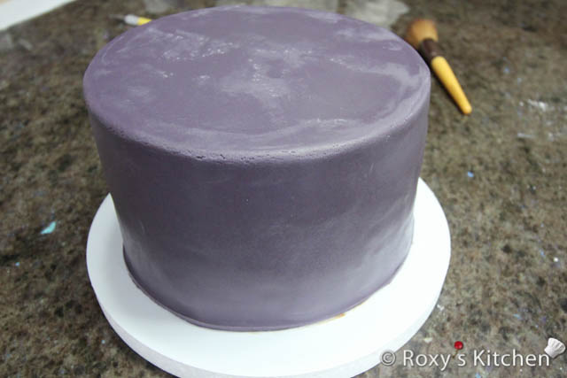 Then, cover the cake with purple fondant. 