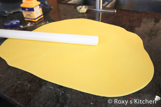 Knead and roll your yellow fondant to cover the cake. 