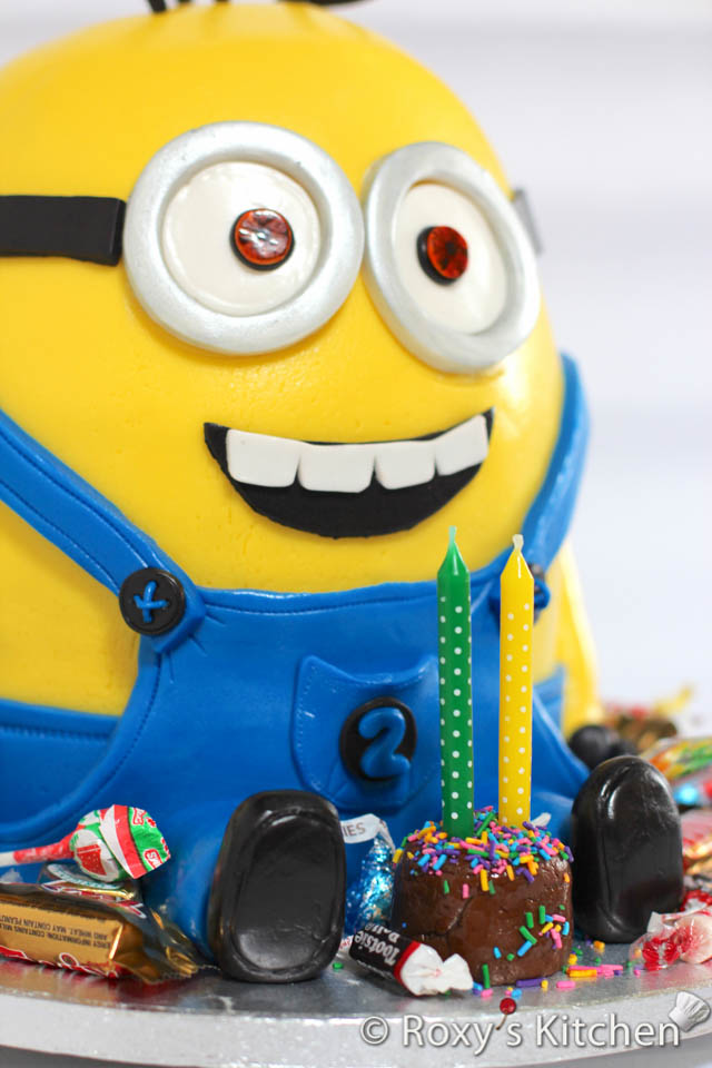 Make a mini cake out of brown fondant. Stick two birthday candles in it and place it in front of the minion. Add lots of candies and small chocolates around the minion cake. These were a big hit with the kids! 