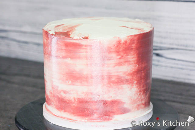 I applied dots of burgundy frosting with a spatula on the sides of the cake. Then, I just used a cake scraper to smooth the frosting on the sides and give it this effect. 