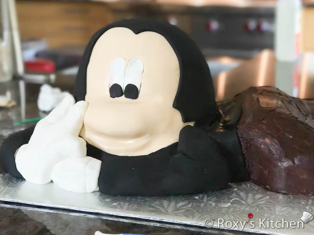 I covered the head and body with black fondant in sections. First the head, then I built Mickey’s arm out of black fondant. And lastly, I covered its upper body. I also shaped his hands/gloves out of white fondant. 
