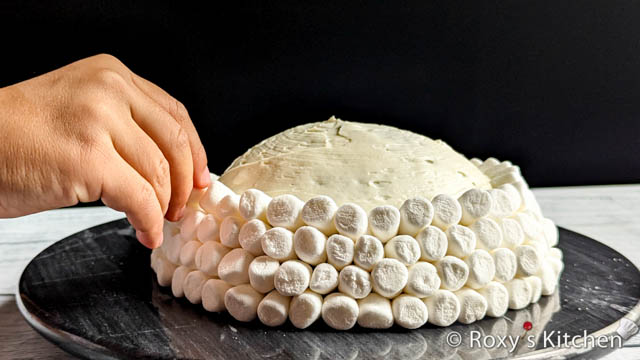 Then, you can begin covering the cake with mini marshmallows. 