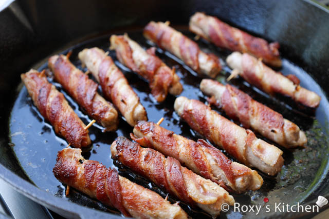 The bacon should become crispy and golden brown, and the sausages should be cooked through.
