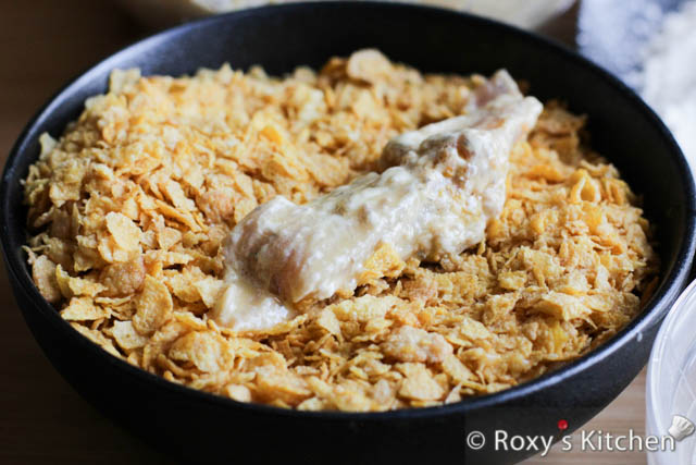 Working with one chicken strip at a time, coat the chicken first in the flour, then in the beaten egg, and finally in the crushed corn flakes. 