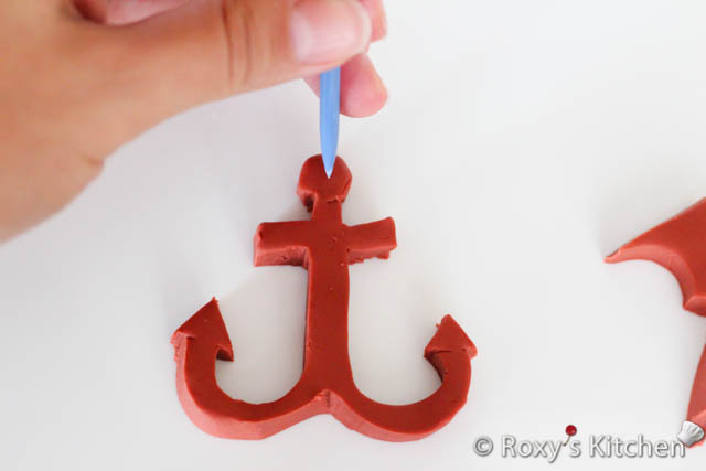 After you cut the anchor shape, use the pointed fondant modeling tool or a skewer to make the hole that anchor ropes pass through. 