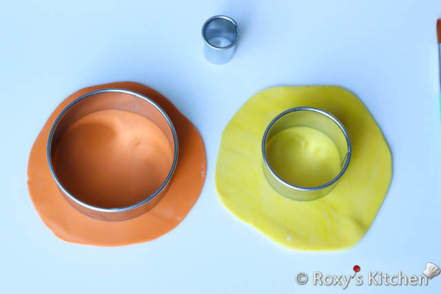 Use the fondant rolling pin to roll out some the orange and yellow fondant about 1/3 cm thick and cut out a circle out of the orange fondant using the 8 cm cutter and another one out of the yellow fondant using the 5 cm (2’’) cutter.  