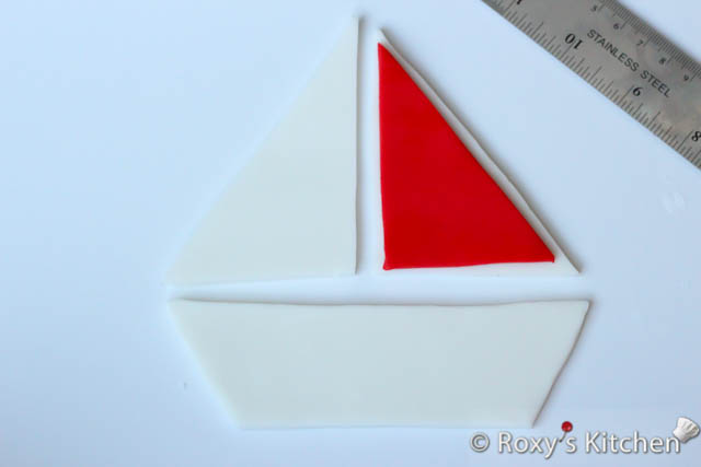 Brush some water on the white sail and place the red piece on top. 