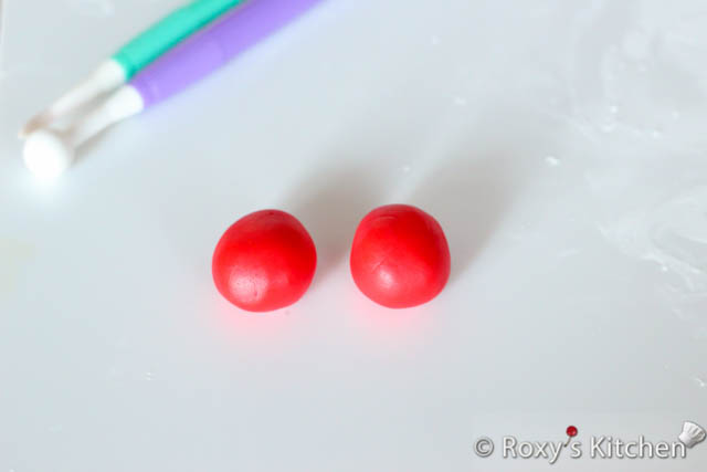Make two balls out of red fondant, each about the size of a gumball. 