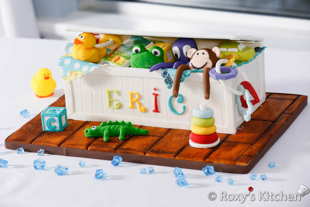 How to Make a Toy Box Cake - In this post, I’ll show you how to make a Toy Box Cake that’s filled with adorable baby toys made out of fondant/gum paste. 