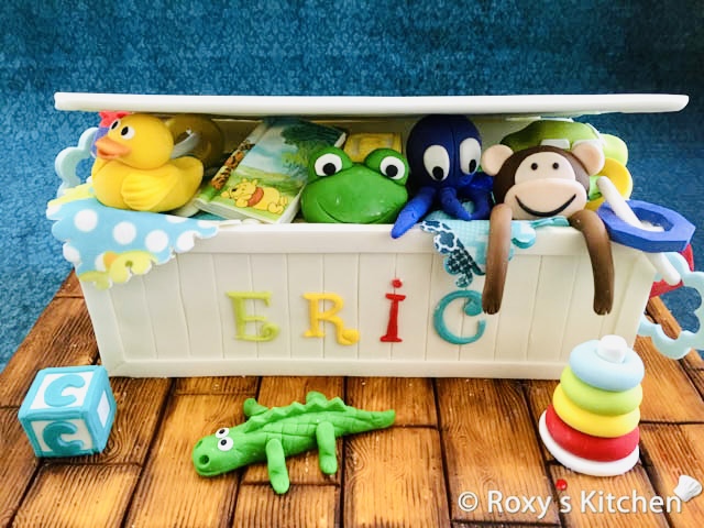 How to Make a Toy Box Cake - In this post, I’ll show you how to make a Toy Box Cake that’s filled with adorable baby toys made out of fondant/gum paste. 