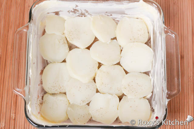 Arrange half of the sliced potatoes in the pan and sprinkle some salt and pepper.