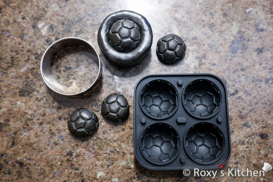 How to Make Tires for Car Cakes - To create the rims, press small balls of modeling chocolate into the soccer ball-shaped silicone mold.